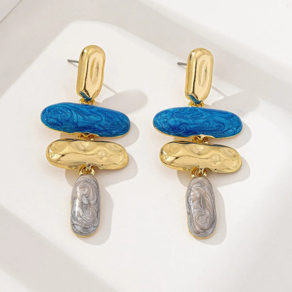 A pair of simple geometric stud earrings with a multicolour metallic electroplated finish.