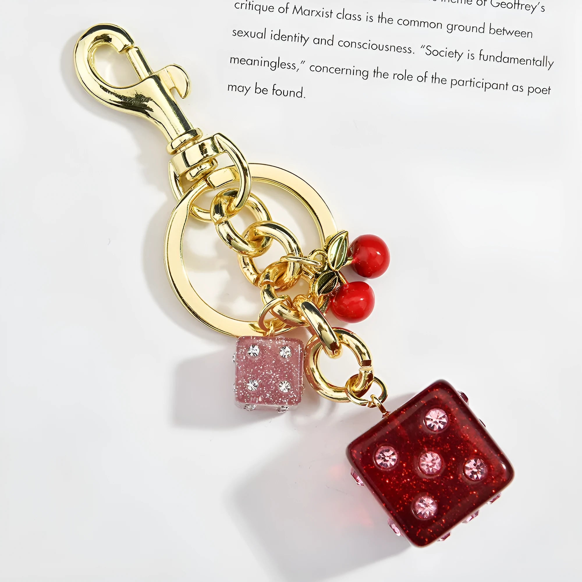 Close-up of a square metal keychain pendant with a vintage cherry two-tone dice pattern.