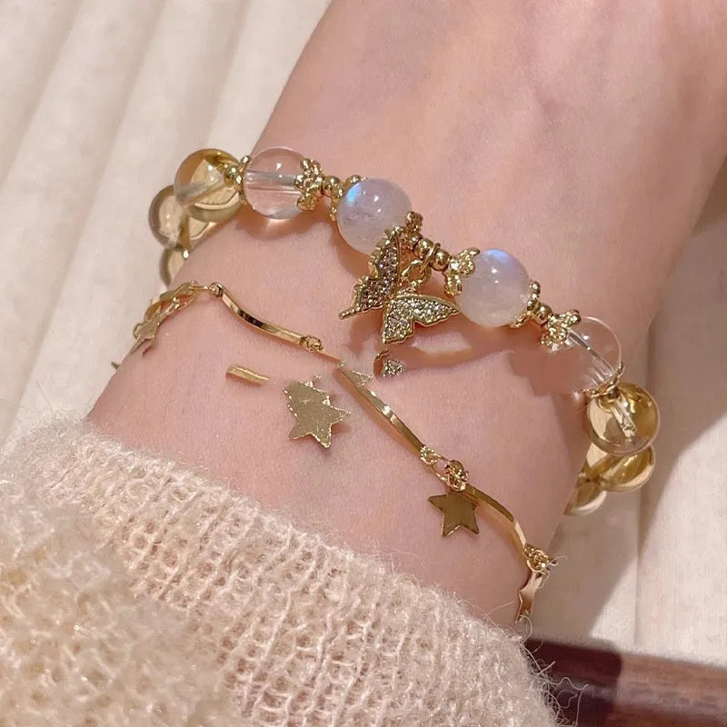 Moonstone white crystal beaded bracelet with citrine butterfly pendant on a white background