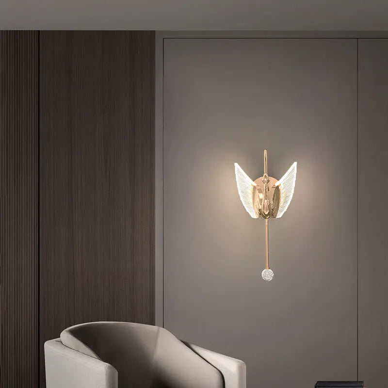 Modern gold swan-shaped wall lamp with acrylic shade mounted beside bed
