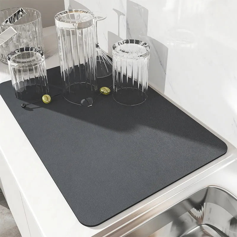 Super absorbent dish drying mat in black PU leather with non-slip rubber backing on a kitchen counter