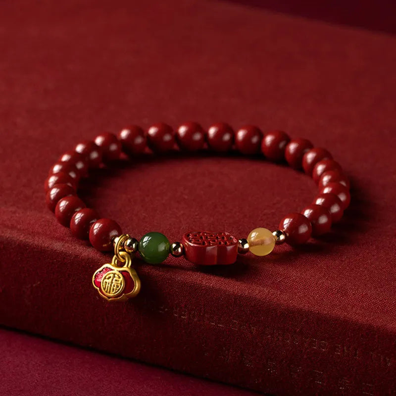 Happy eyebrow bracelet with emperor sandstone beads and a central carved fu charm on a string.