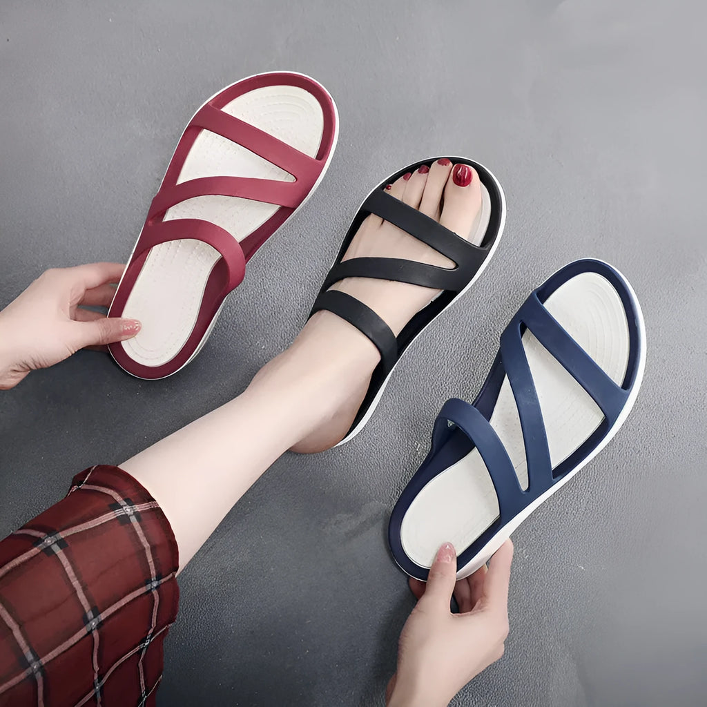 Women's solid colour casual sandals on a beach background, showing red, blue, and black colour options.