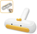 Portable yellow pet hair remover brush with duck design on a fabric sofa.