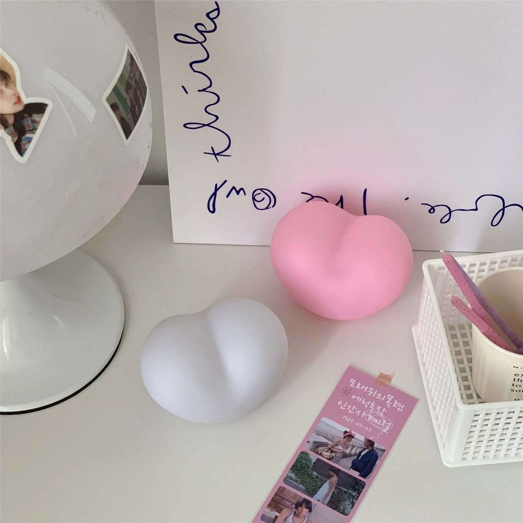 White or pink vinyl atmosphere lamp emitting warm light, shown in small and large size options.