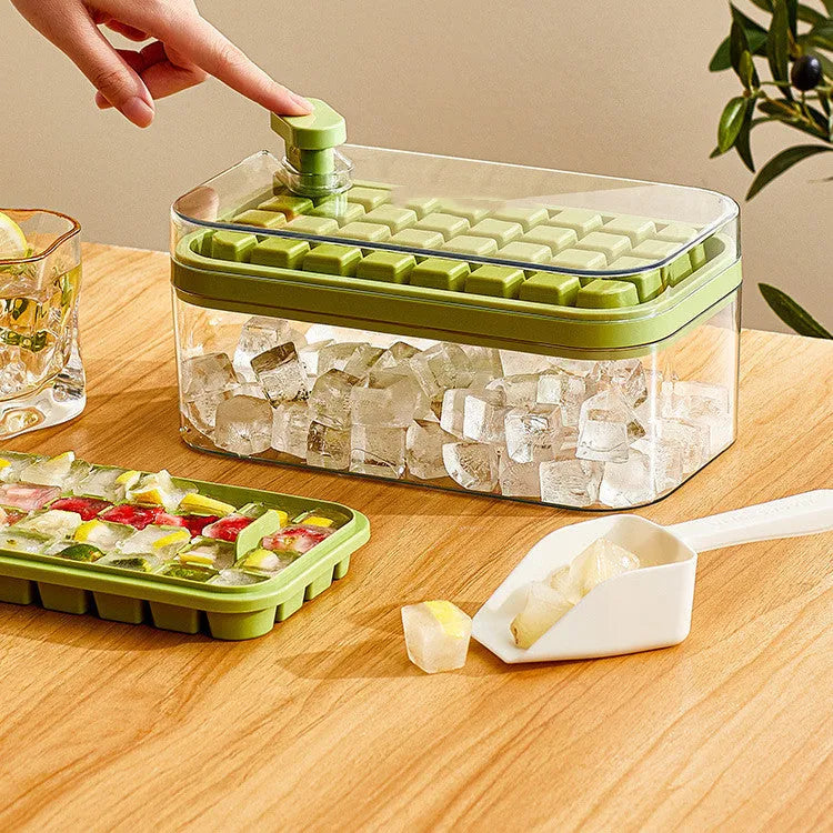 One-touch press ice cube maker mould box with green lid, ice cubes, and shovel on white background