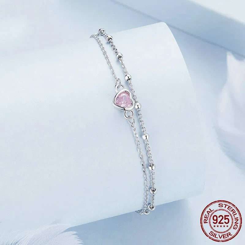 Sweet girlish heart-shaped sterling silver bracelet with adjustable chain on a white background.