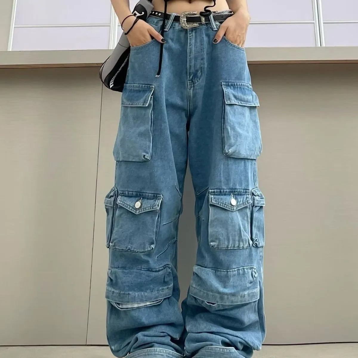 Blue high waist wide leg women's trousers with multiple pockets on a street style background.