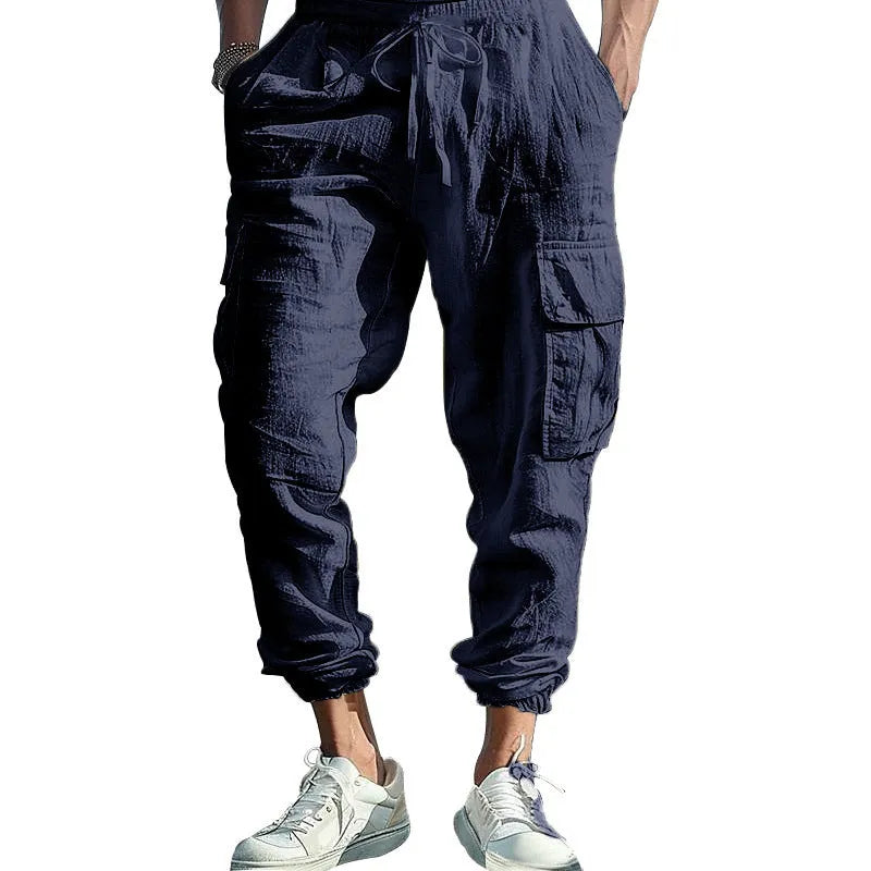 Men's ankle-tied loose fit linen casual trousers in army green, showing multiple pockets and drawstring waist.