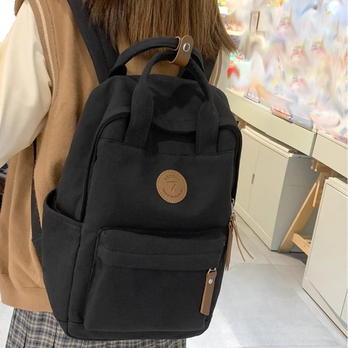 Black Oxford cloth leisure backpack with curved shoulder straps showing retro sewing thread details