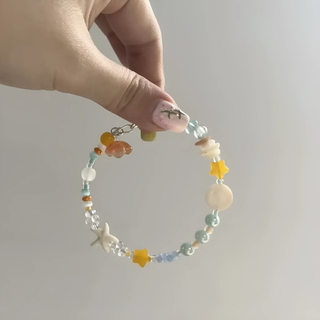 Orange seaside bracelet for women with diamond-shaped charm and round decorative elements on mixed material band