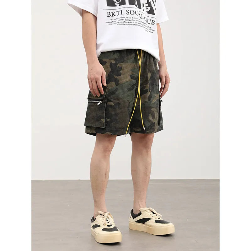 Multi-pocket camouflage workwear shorts for men with mid-waist cropped design and thin fabric, shown in a flat lay.
