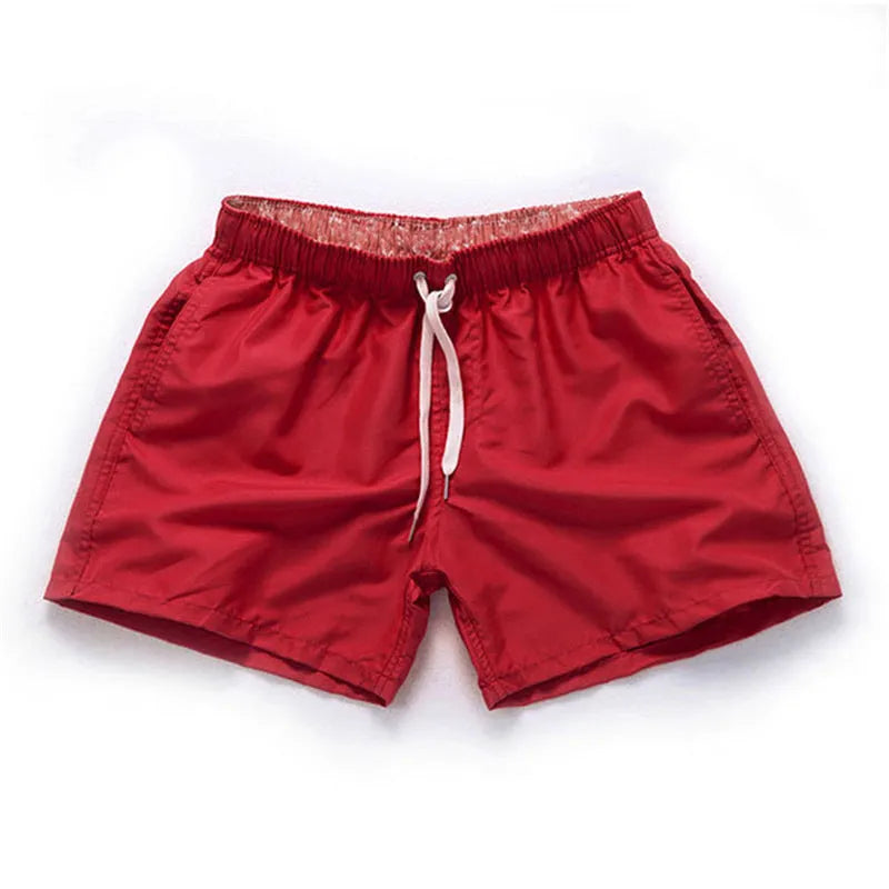 Men's straight-leg beach shorts in black polyester fabric on a size chart.