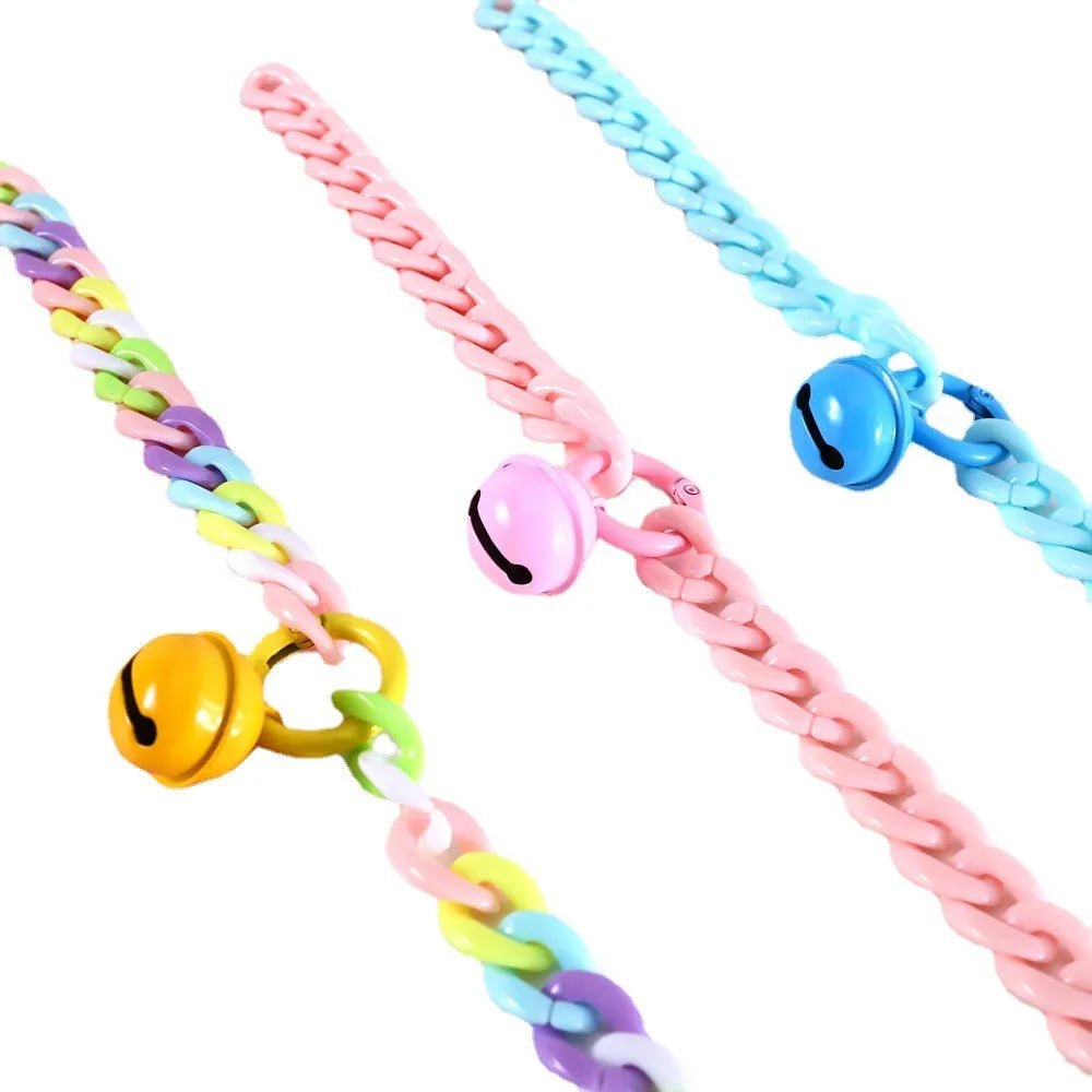 Adjustable plastic pet collar in macaron candy colours on a table, showing chain blue, pink, and mixed colour variants.