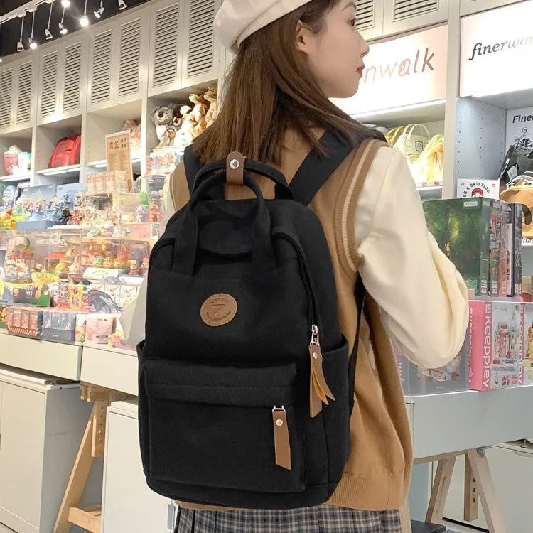Black Oxford cloth leisure backpack with curved shoulder straps showing retro sewing thread details