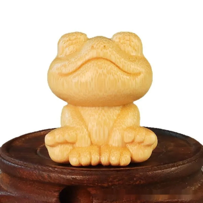 Solid bamboo carved ornament of a smiling cartoon frog, 5cm tall.