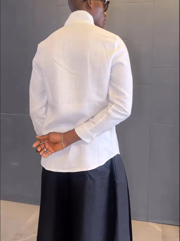 White asymmetric long sleeve shirt with black pleated pants set on a model for casual wear