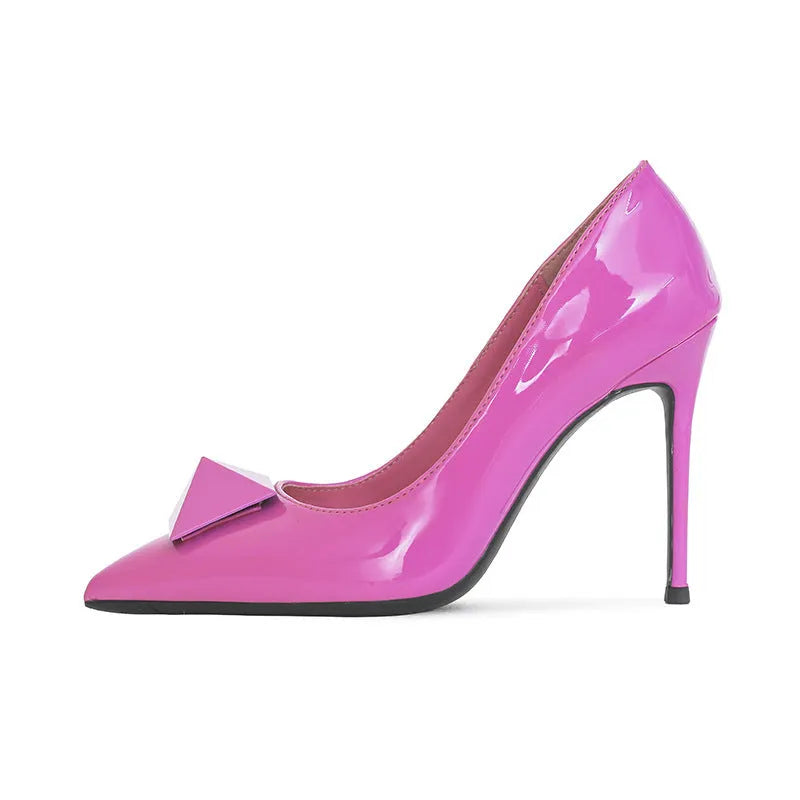 Pink women's patent leather pointed toe stiletto heels with a buckle, shown on a white background.