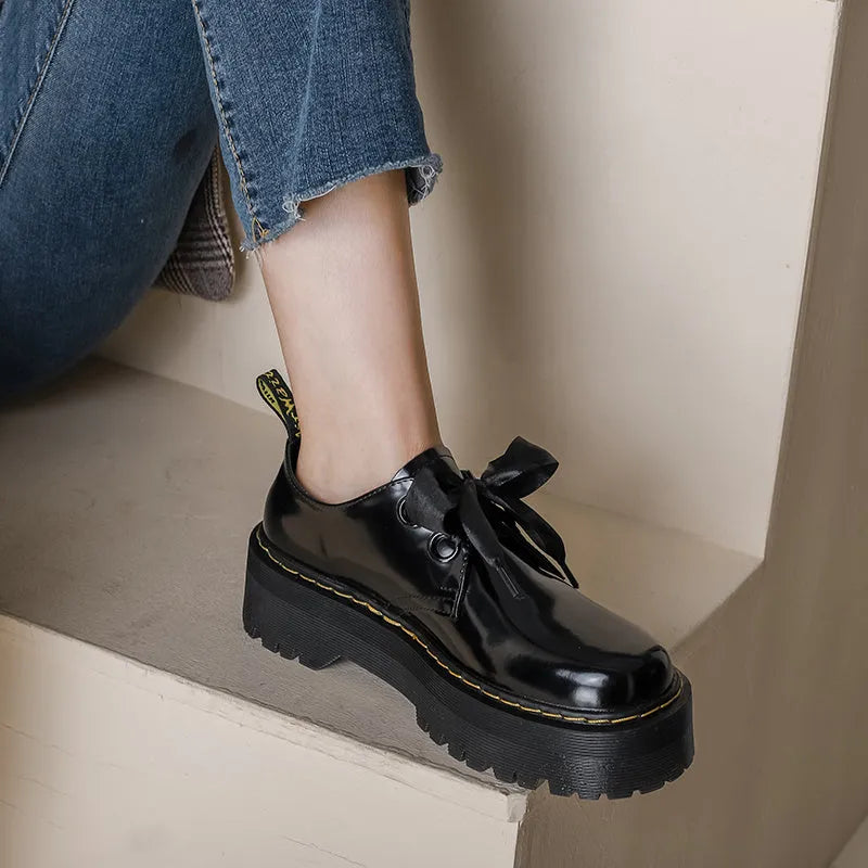 Women's black leather shoes with thick sole and cross-strap design