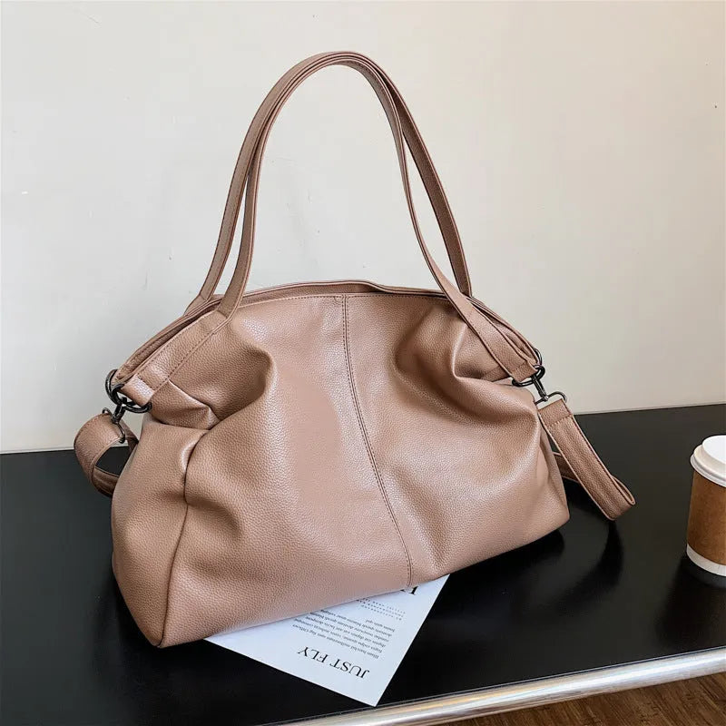 Large soft surface PU messenger bag in horizontal square shape with shoulder strap and top handle.