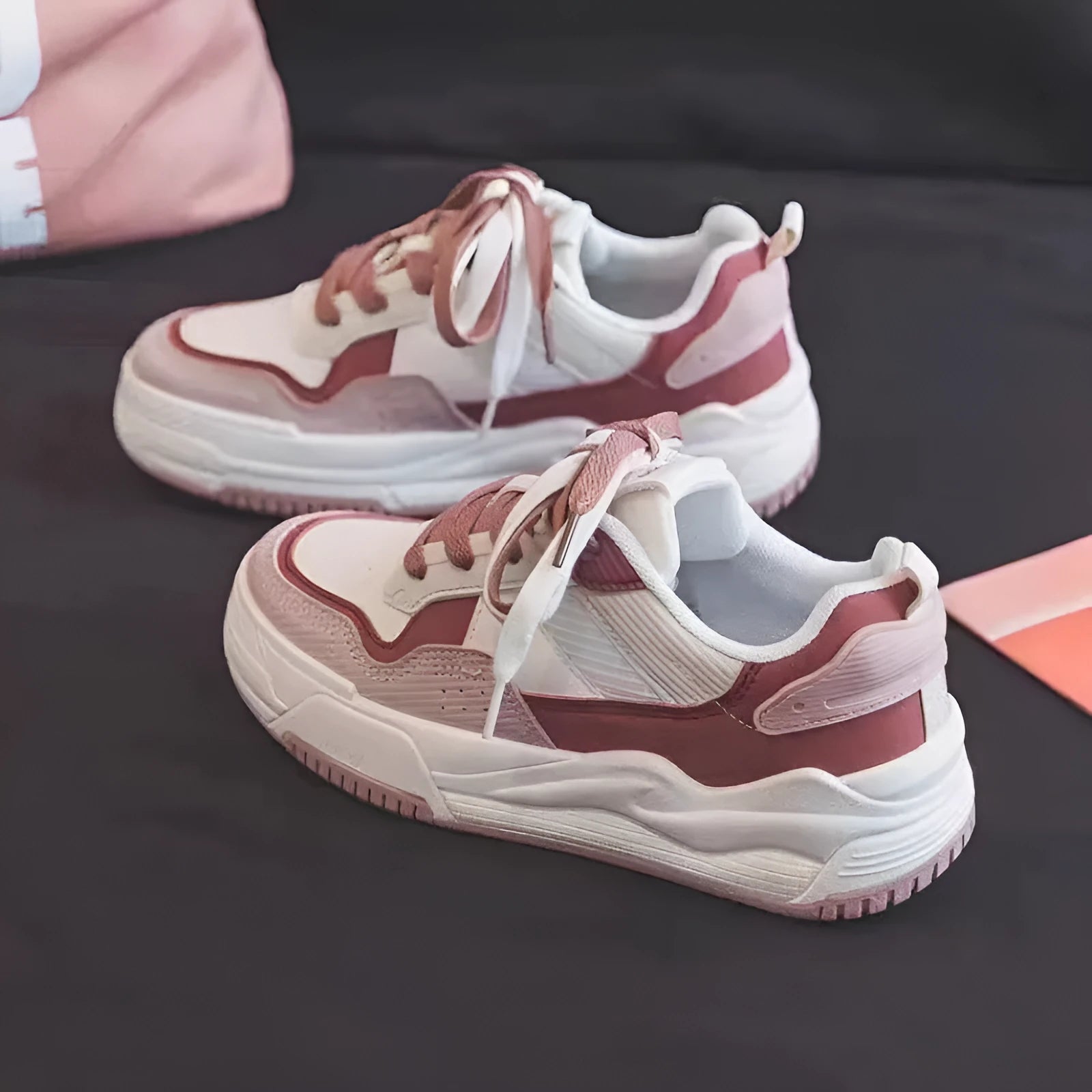 Women's pink low top sneaker with a rubber platform sole on a white background.