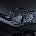 Black head-mounted smart glasses with a camera lens and touch controls on the frame.