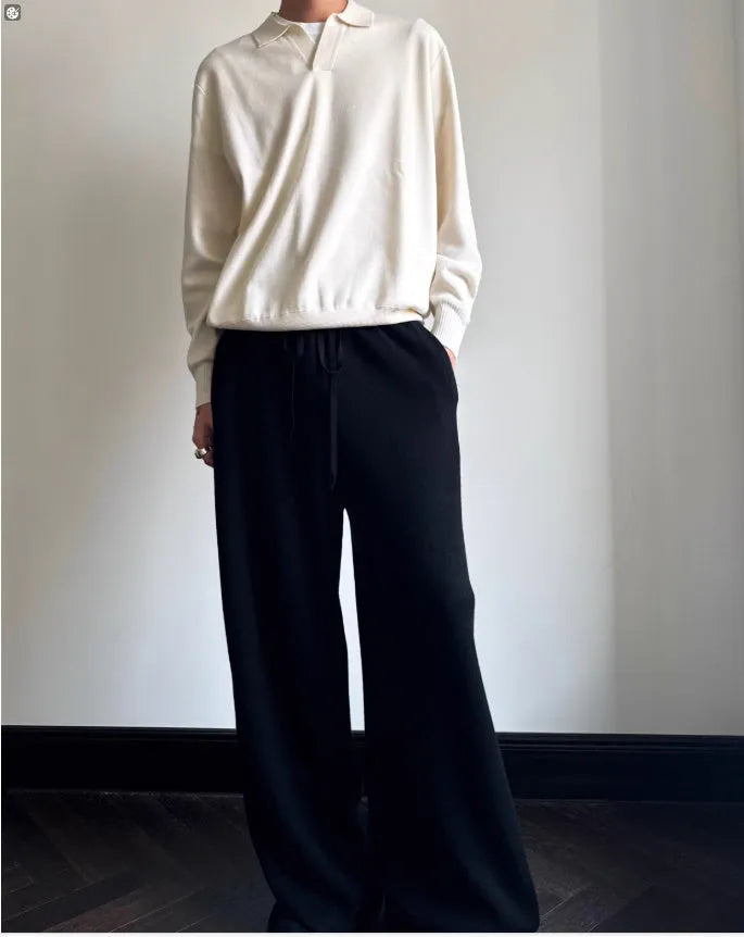 Man wearing a milky white pure wool polo sweater with a lapel collar.