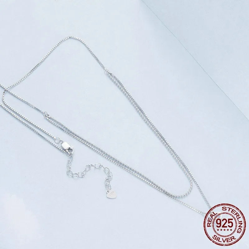 Silver double-layer necklace with pearl chain and sterling silver pendant.