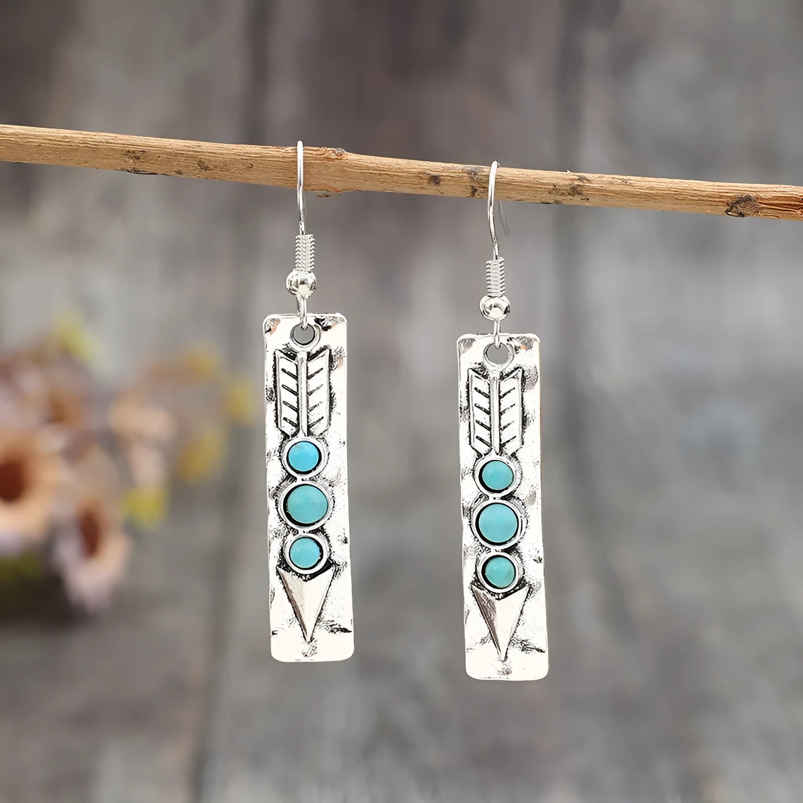 Long strip geometric silver earrings with inlaid turquoise detail on a white background