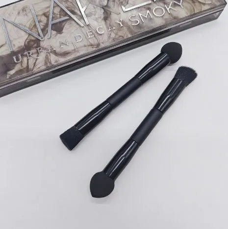 Double-headed black makeup brush with angled sponge and concealer brush on wooden handle