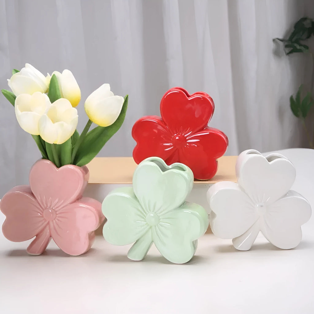 White porcelain clover ceramic vase in European style on a desktop.