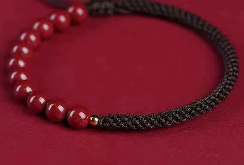 Braided rope bracelet with cinnabar beads in 8mm diameter and wine red colour