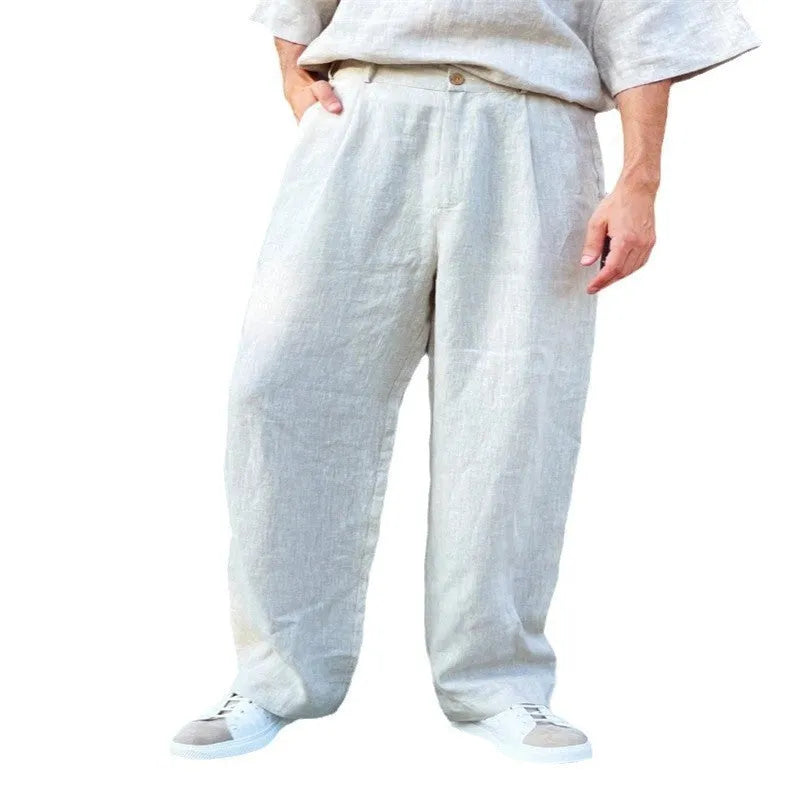 Men's loose linen pleated high waist jogger pants in black, side view showing straight-leg cut and zipper fly