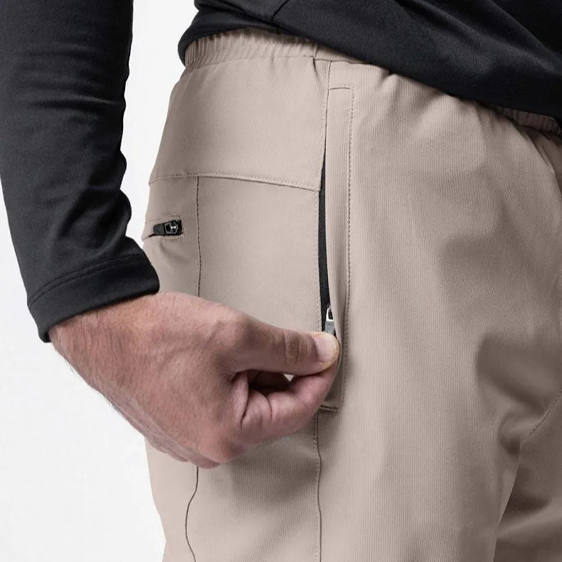 Men's grey quick-dry fitness trousers with ankle-tied design on exercise equipment
