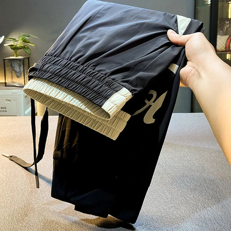 Men's black ultra-thin ice silk ankle banded cropped casual trousers on hanger