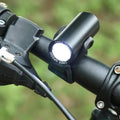 Black rechargeable 350 lumen USB bicycle front light mounted on handlebars for night cycling