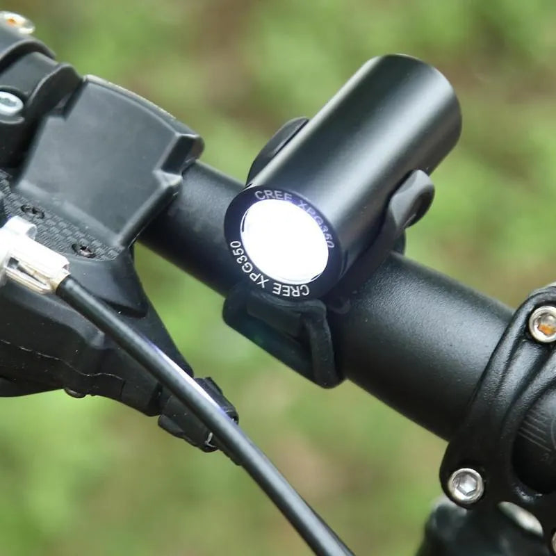 Black rechargeable 350 lumen USB bicycle front light mounted on handlebars for night cycling