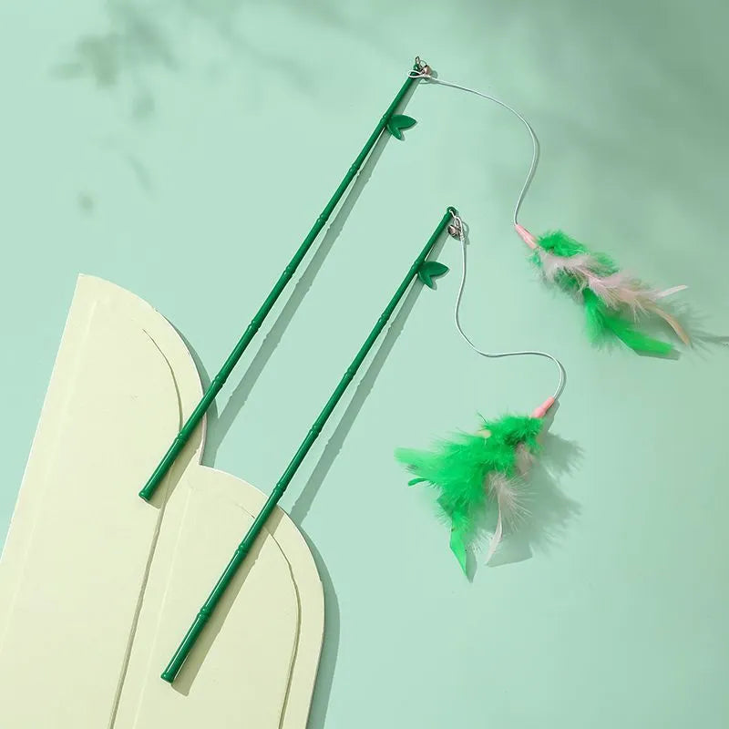 Green interactive cat toy feather wand with bell refills and feathers on a white background
