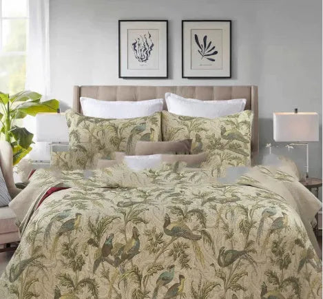 Blue cotton bedspread set with American floral and bird pattern laid on a bed.