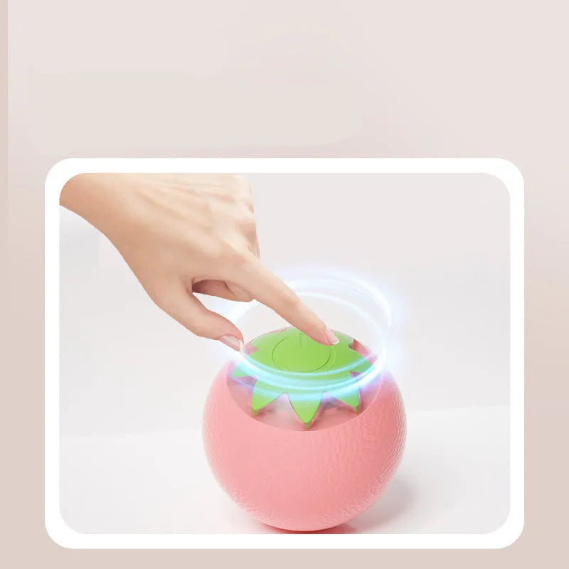 Electric rolling ball toy for dogs and cats in green, pink, and yellow on a light background