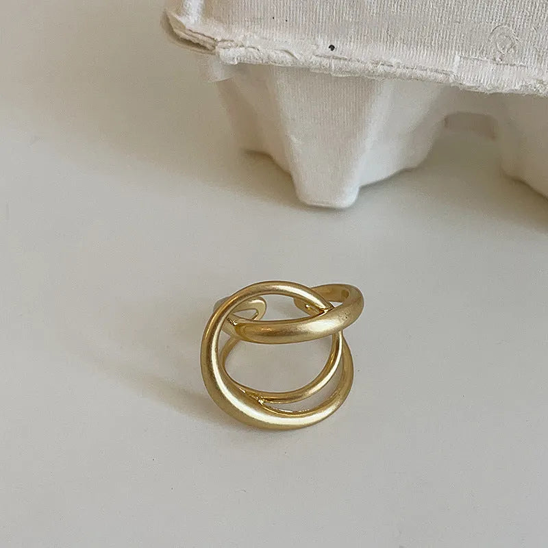 Geometric open ring with three-dimensional interlaced design in matte metal