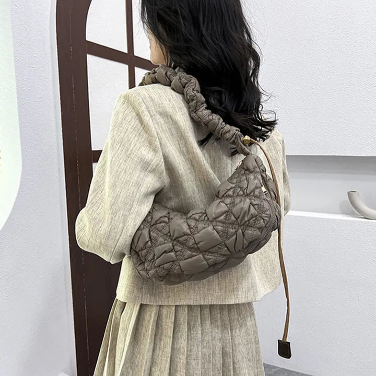 Women's light beige nylon underarm messenger bag with a long shoulder strap.