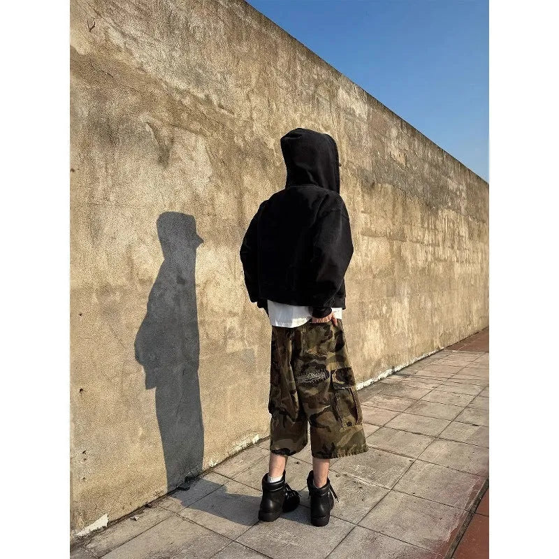 Men's loose-fit camouflage cropped jeans with ripped knees and retro patches on a straight-leg.