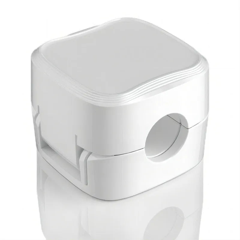 Magnetic cable clip in white holding a USB cable under a desk, with adhesive backing visible