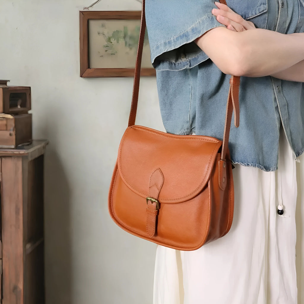 Genuine leather messenger bag with shell shape and sewing line detail in brown
