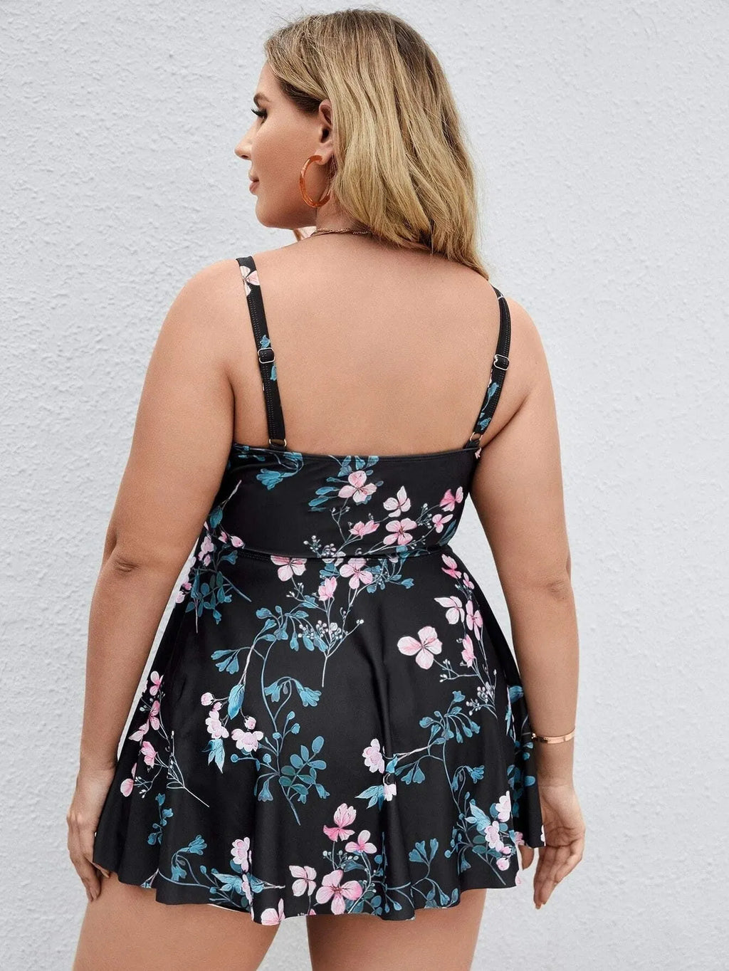 Women's floral print one-piece swimsuit on a hanger, showing split colour design.