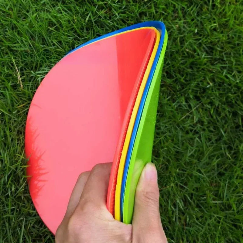 Yellow flexible TPE football training target disc, 23cm diameter, lying flat on grass.