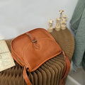 Genuine leather messenger bag with shell shape and sewing line detail in brown