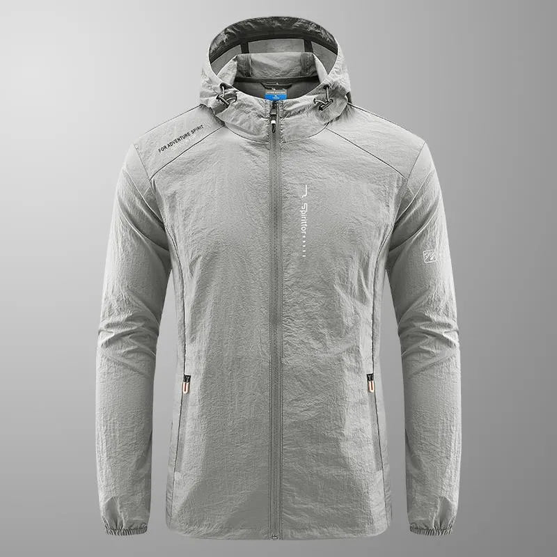 Man wearing a light grey hooded summer jacket outdoors.