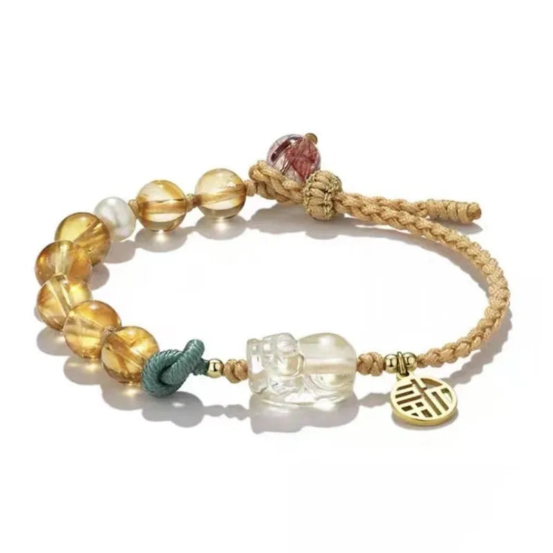 Hand-woven citrine crystal bracelet with zodiac design on neutral background